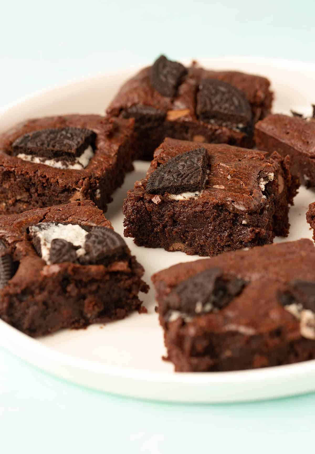 A white plate covered in perfectly sliced Oreo Brownies.