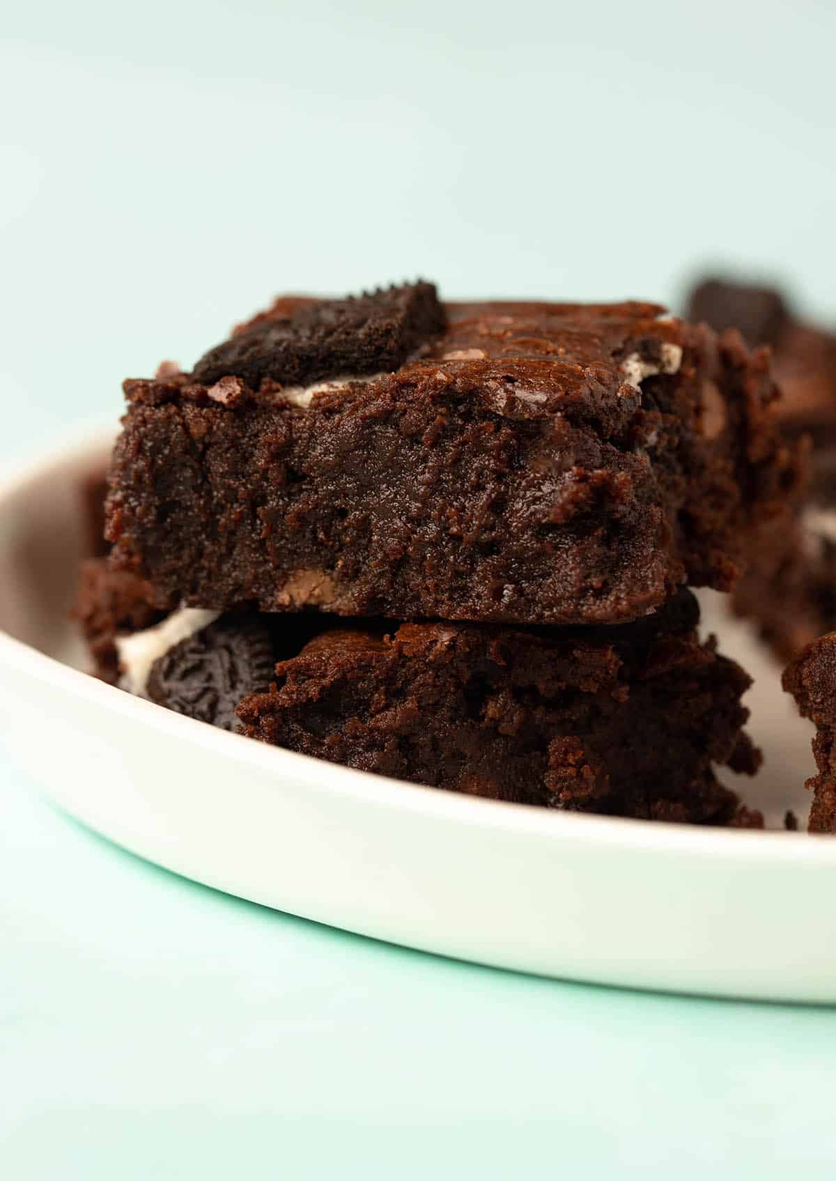 A stack of homemade Oreo Brownies on a white plate.