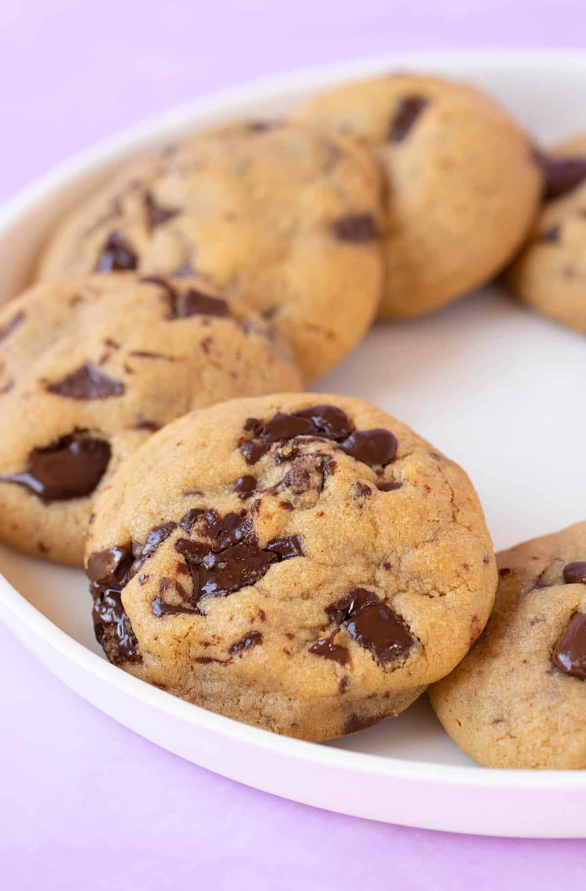 A white plate filled with gooey Peanut Butter Chocolate Chip Cookies. 
