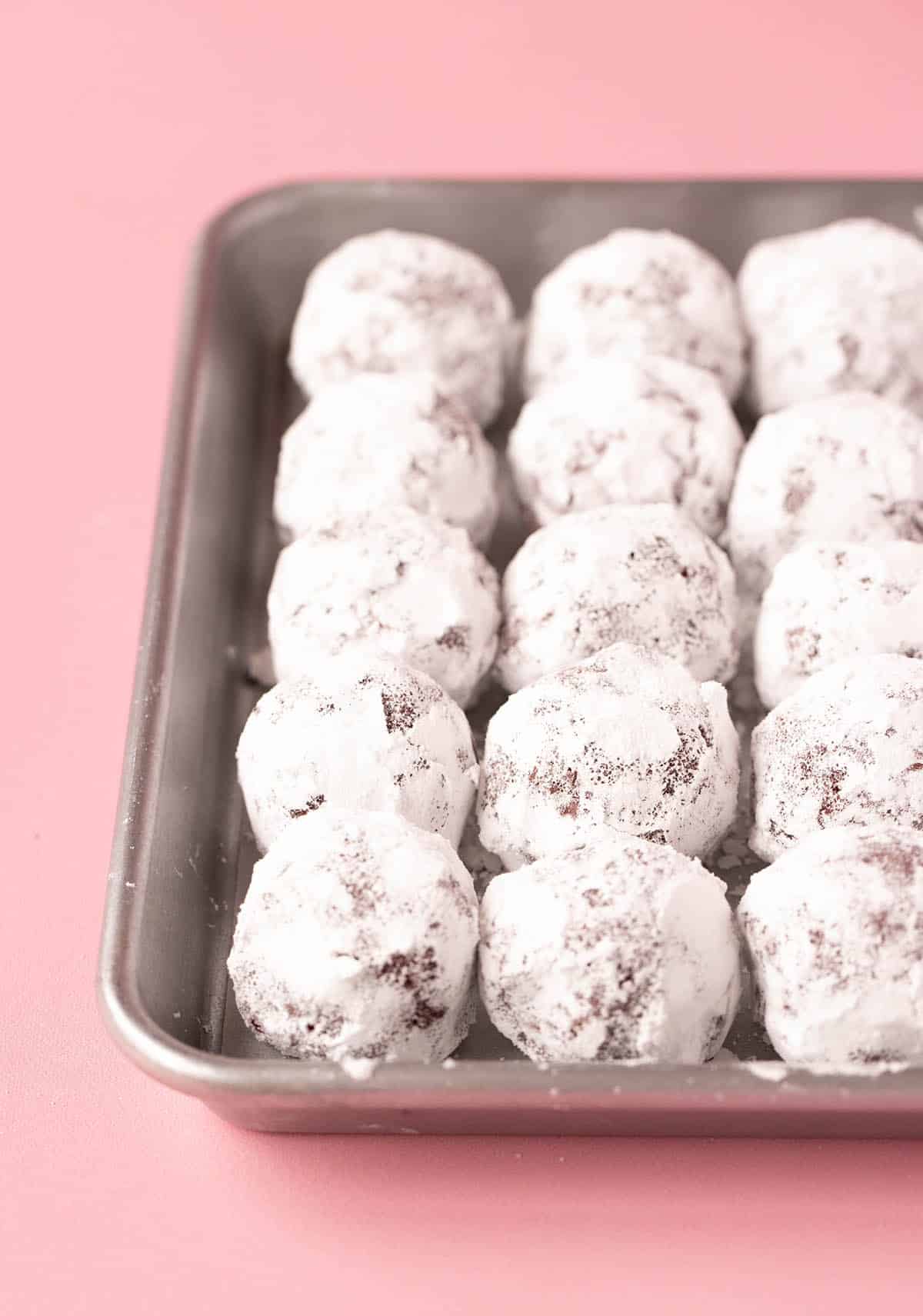 Snow white cookie dough balls in a baking ready to bake.