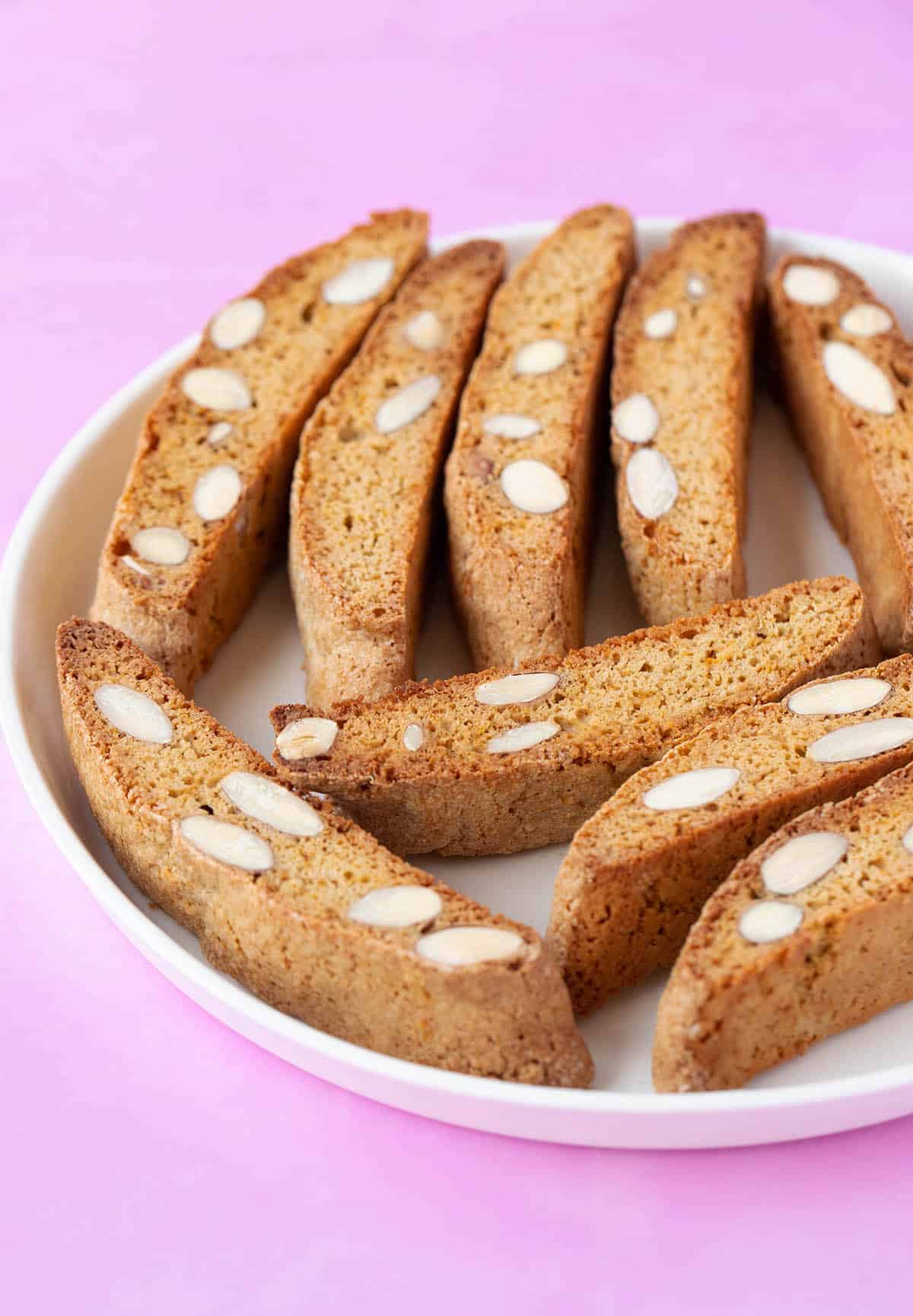 A plate of homemade Orange Almond Biscotti on a pink backdrop.