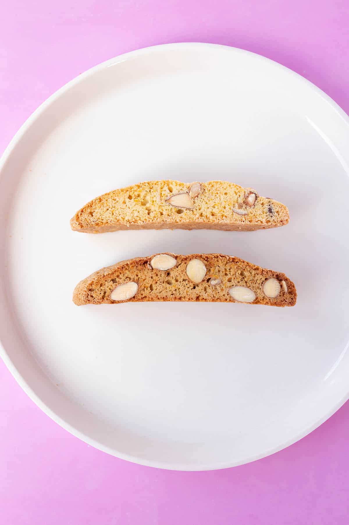 Two Biscotti on a white plate showing the difference in white and brown sugars.