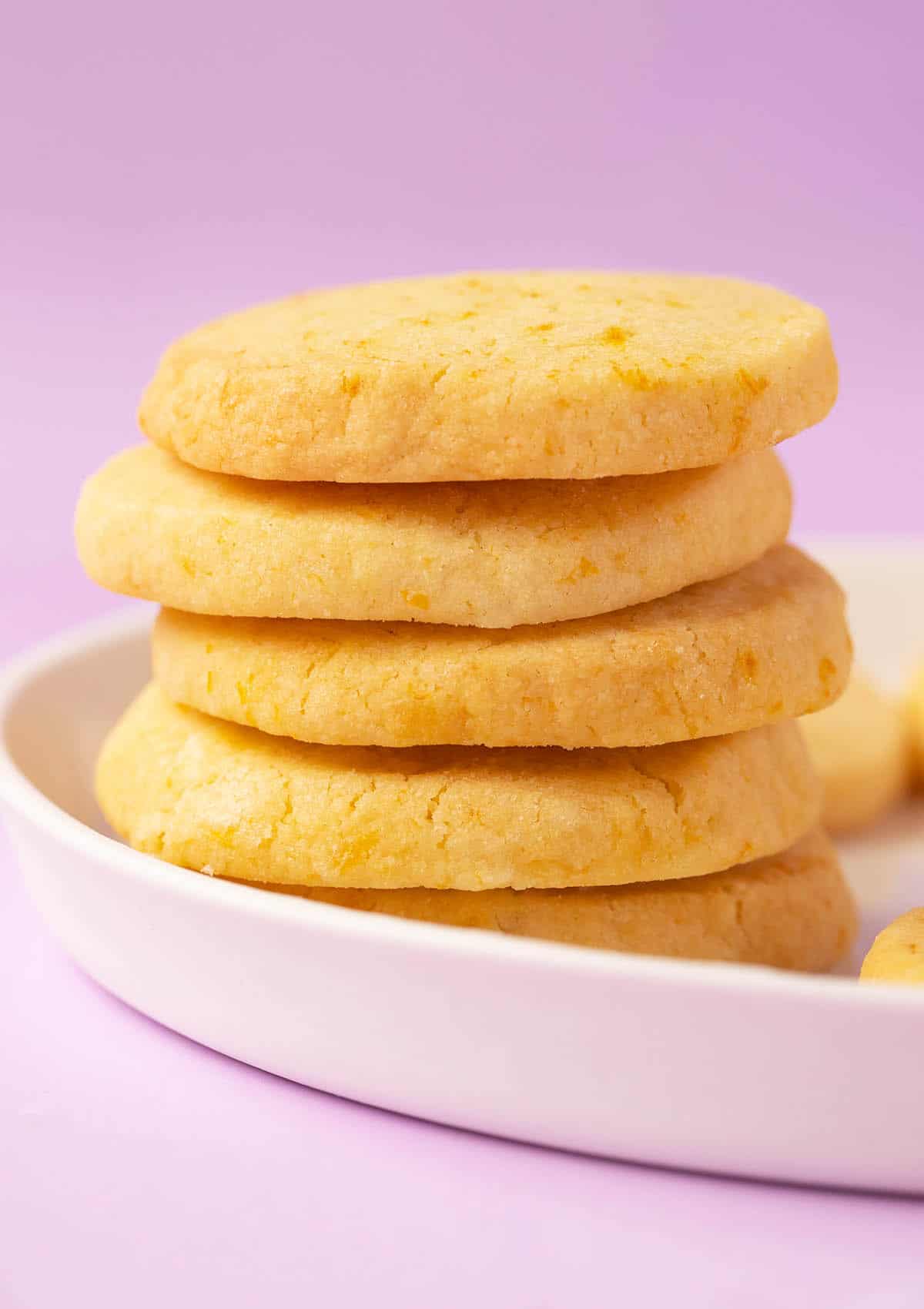 A stack of thick cut Orange Shortbread Cookies on a white plate.