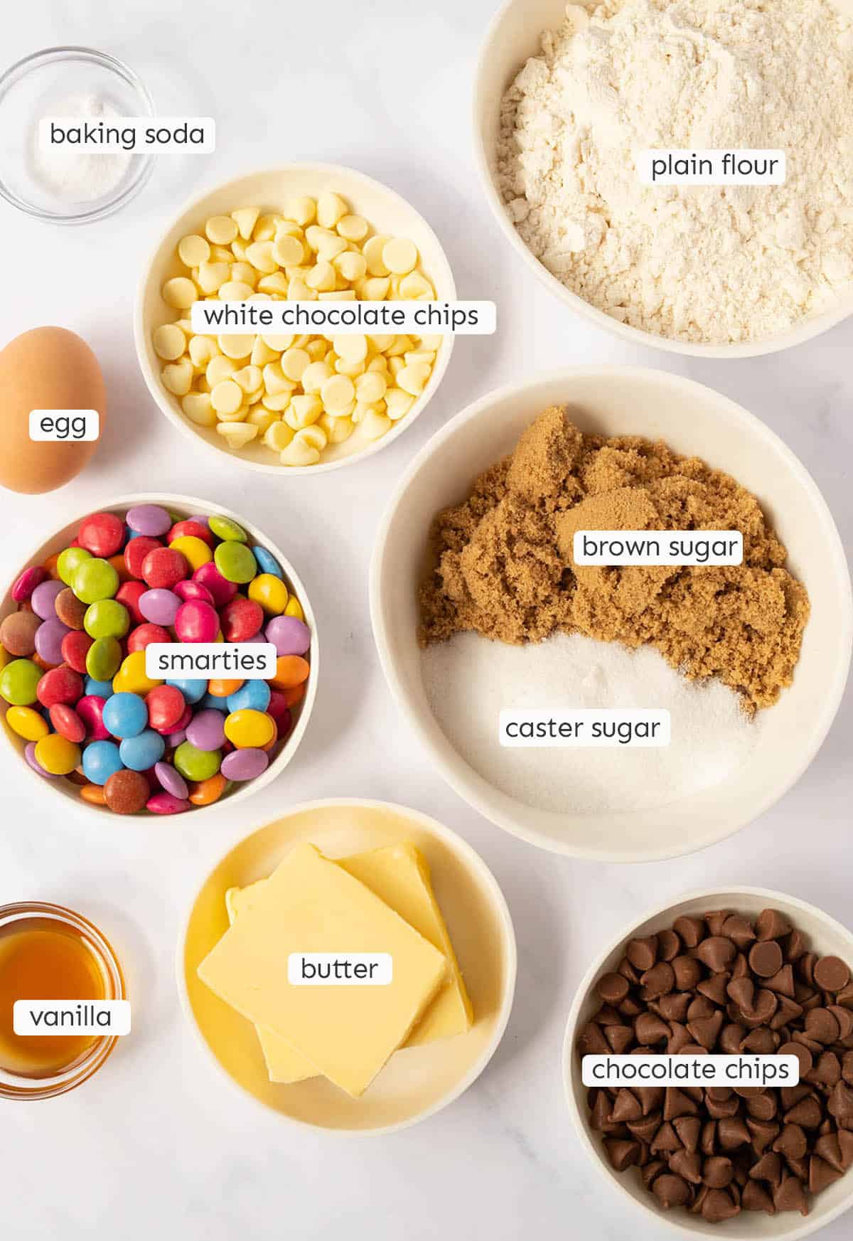 All the ingredients needed to make cookies from scratch on a marble background. 