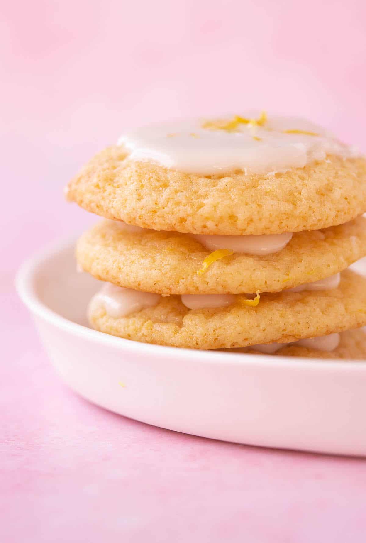 A stack of homemade Italian Ricotta Cookies decorated with lemon zest.