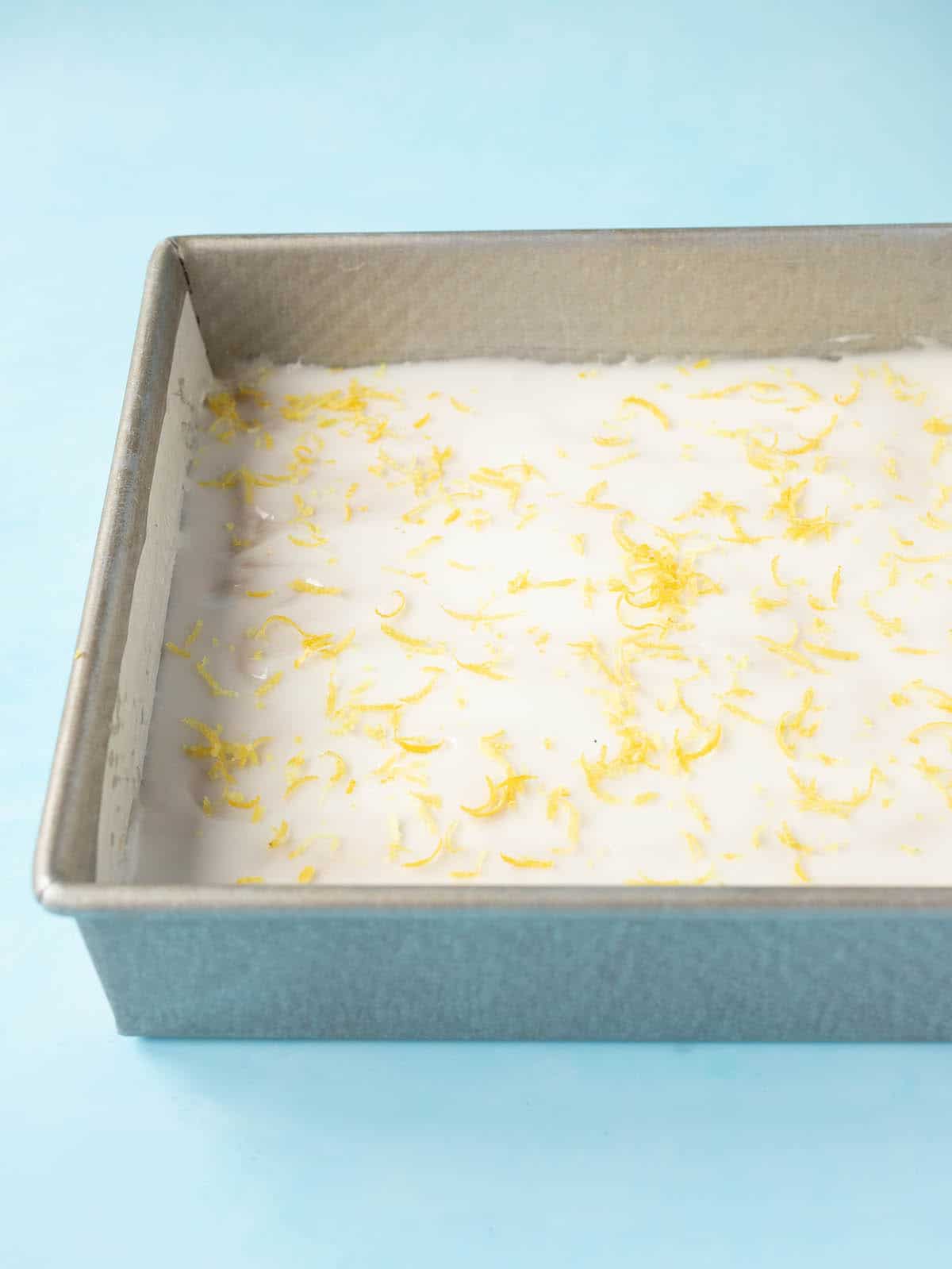 A baking pan filled with Lemon Slice decorated with fresh lemon zest. 