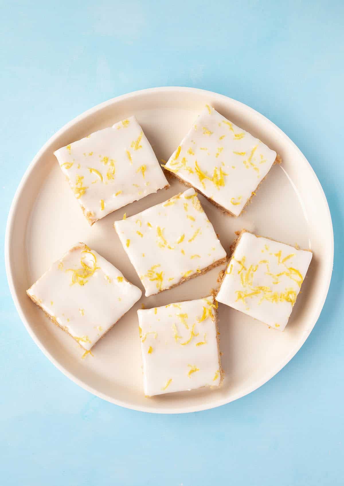 Top view of a plate of Lemon Slices decorated with lemon zest. 