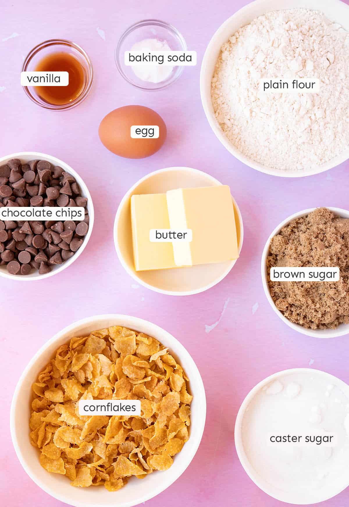 All the ingredients needed to make Cornflake Cookies on a pink background. 