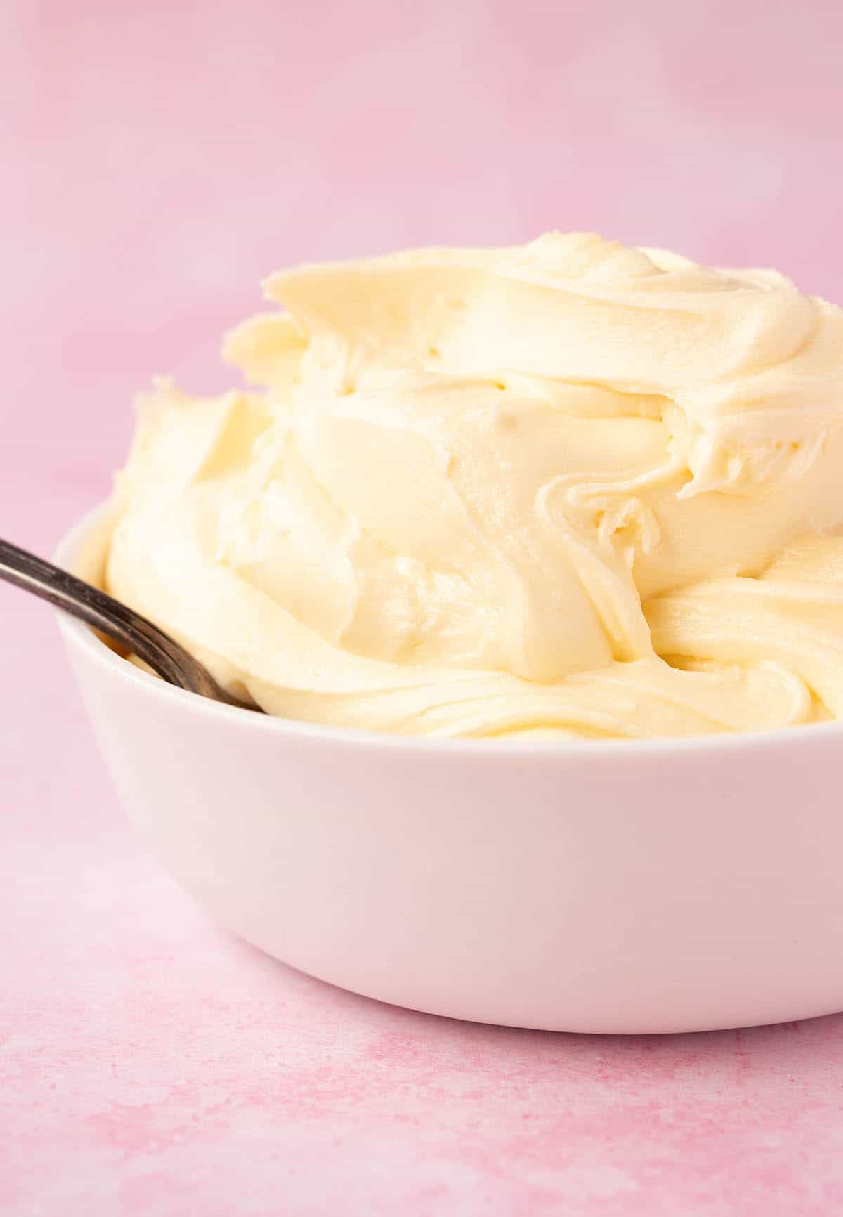 A white bowl filled with white chocolate buttercream.