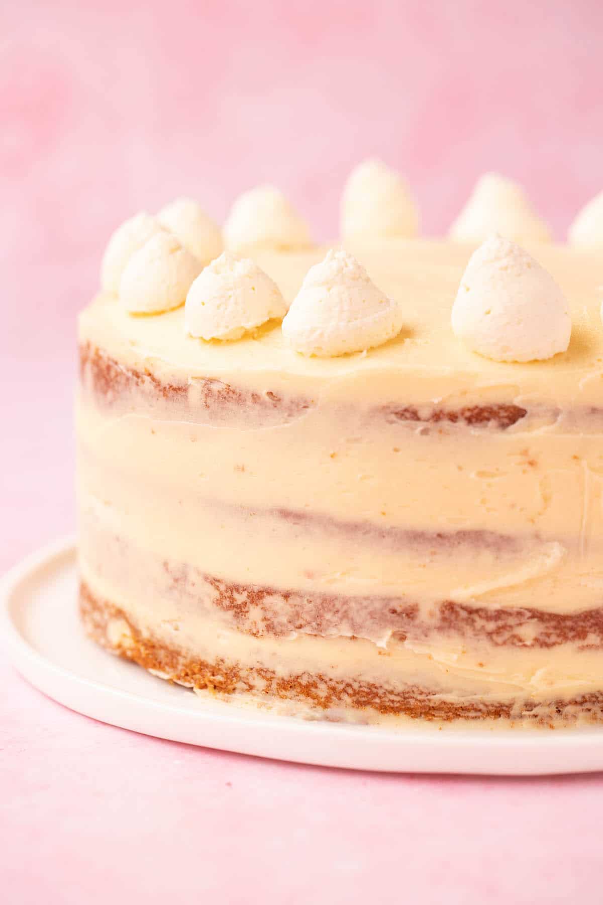 A four layer Honey Cake sponge covered in honey buttercream on a white serving plate. 