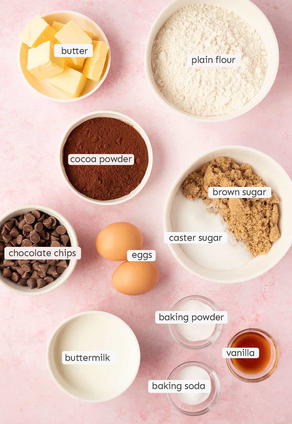 All the ingredients needed to make Chocolate Bread from scratch on a pink backdrop. 