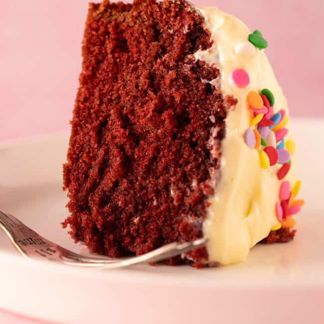 A beautiful red velvet cake decorated with sprinkles.