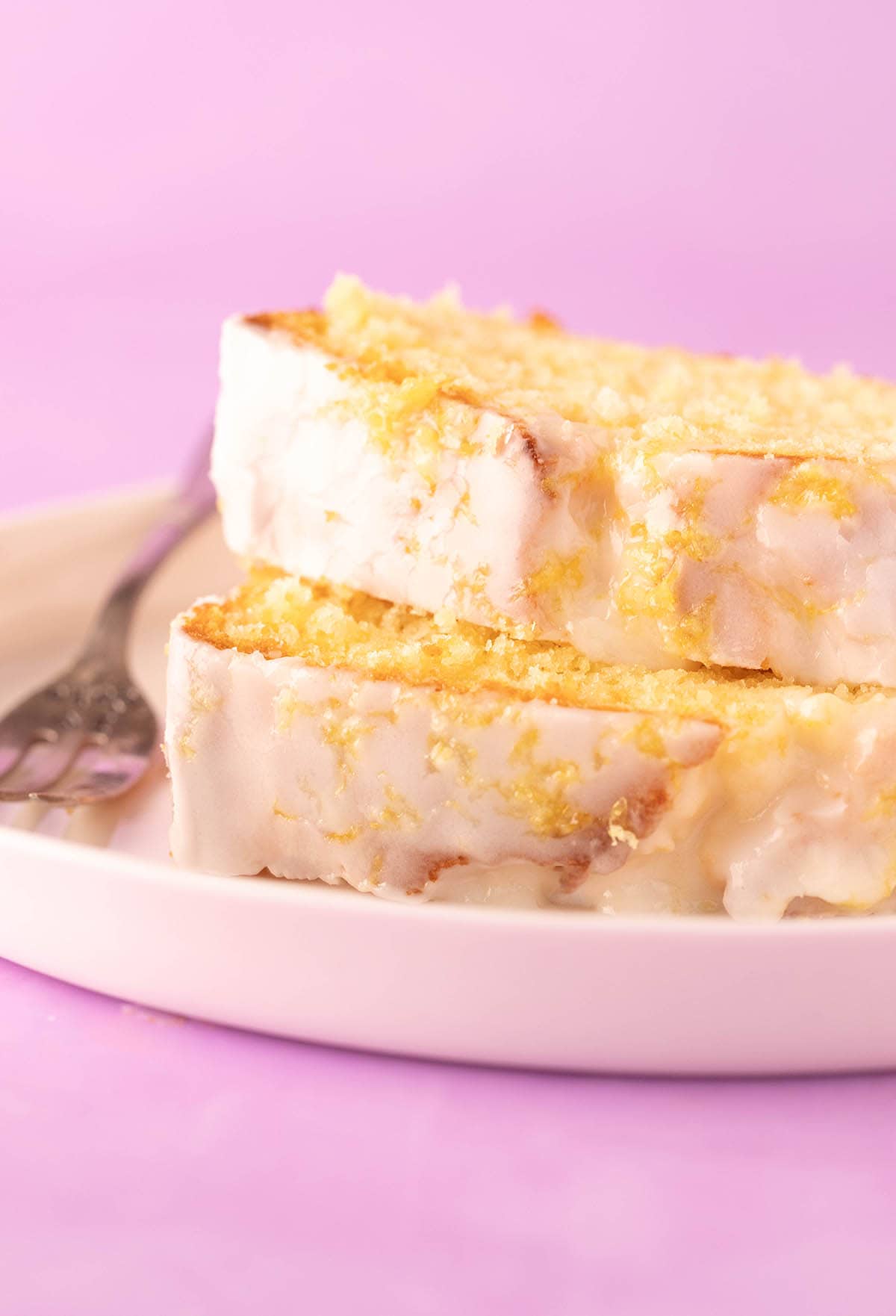 Two thick slices of lemon pound cake on a white plate. 