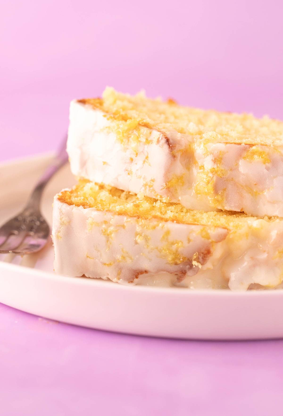 Two thick slices of lemon pound cake on a white plate. 