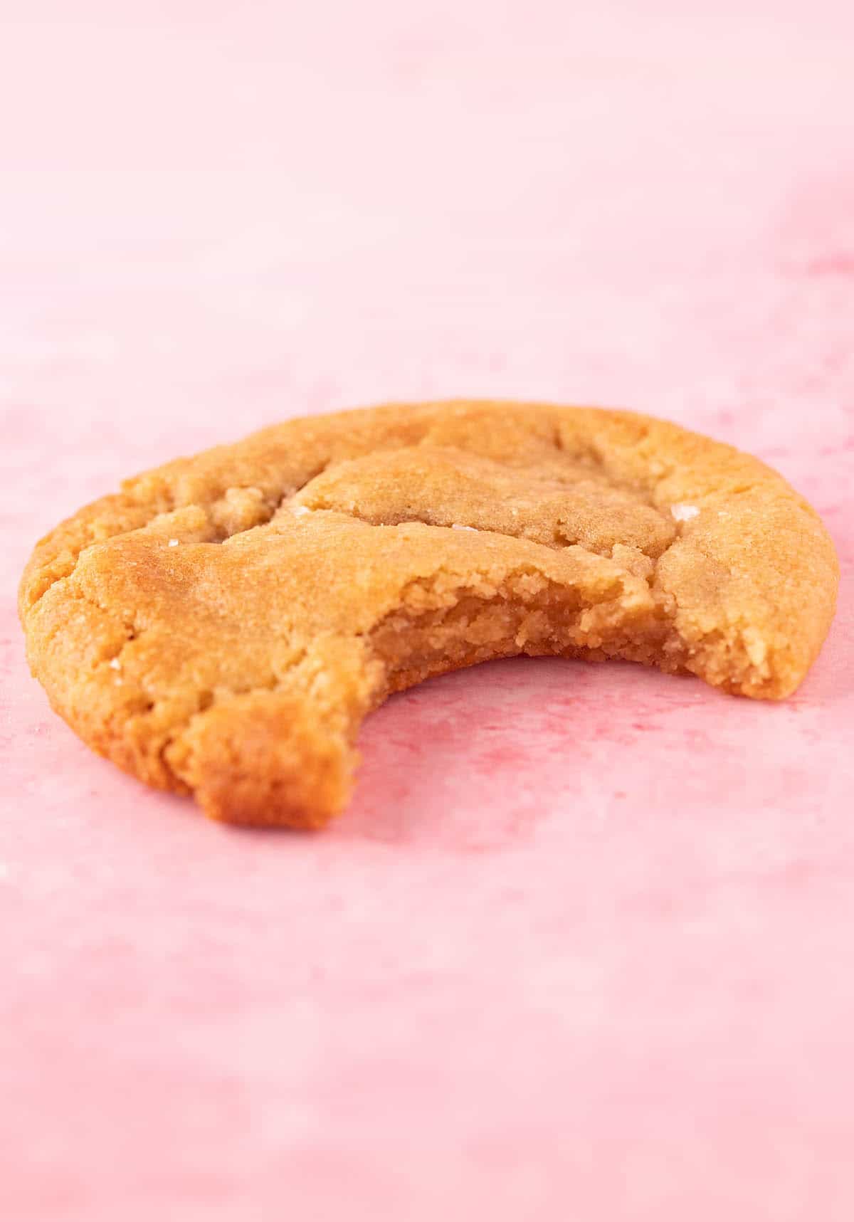 A homemade peanut butter miso cookies with a bite taken out of it.