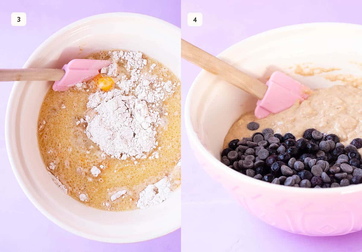 A pink mixing bowl filled with muffin batter. Chocolate chips and blueberries being added.