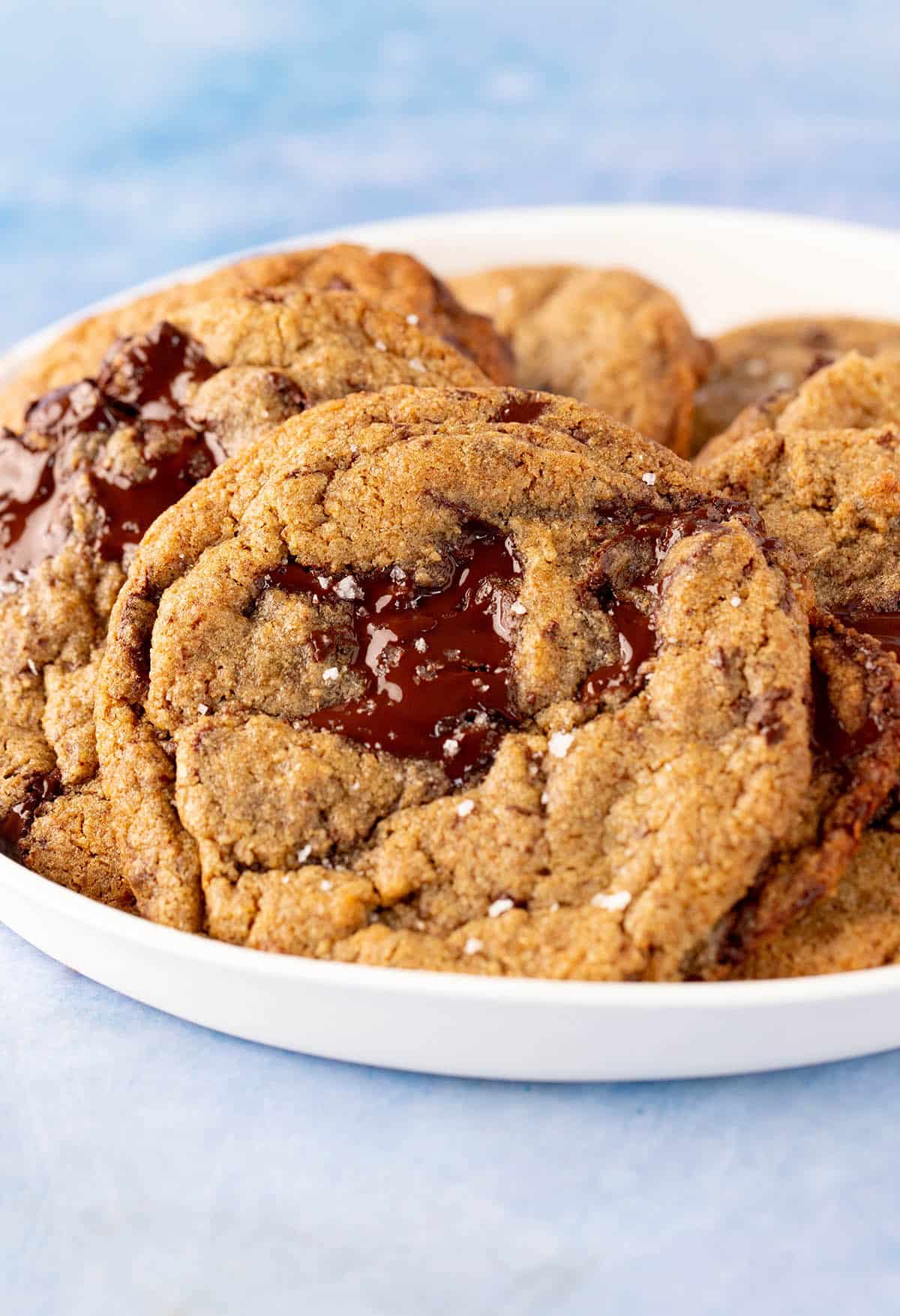 A plate of homemade Rye Chocolate Chip Cookies on a blue backdrop.