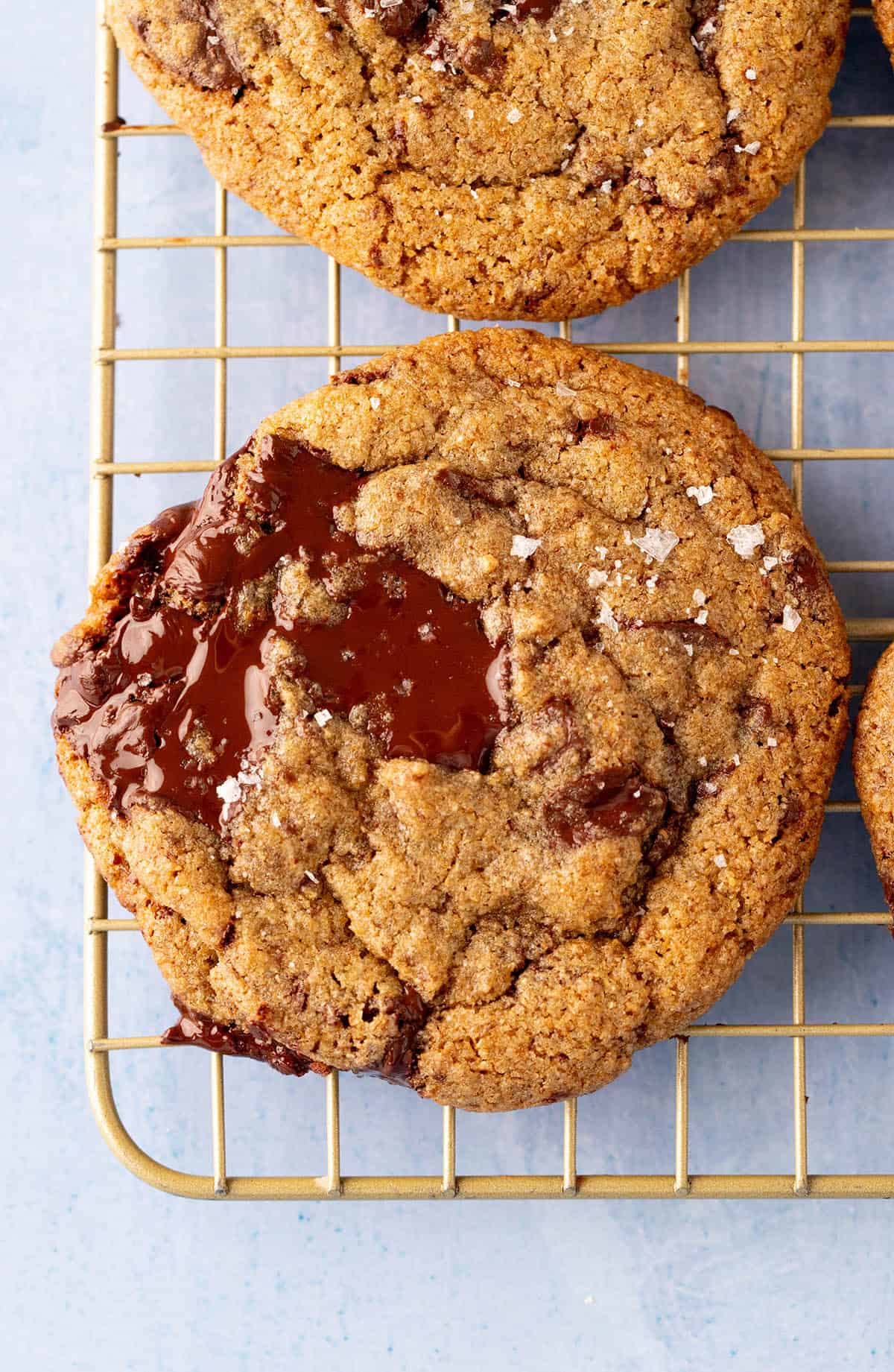 Close up of a gooey Rye Cookies with dark chocolate puddles and flakey sea salt.