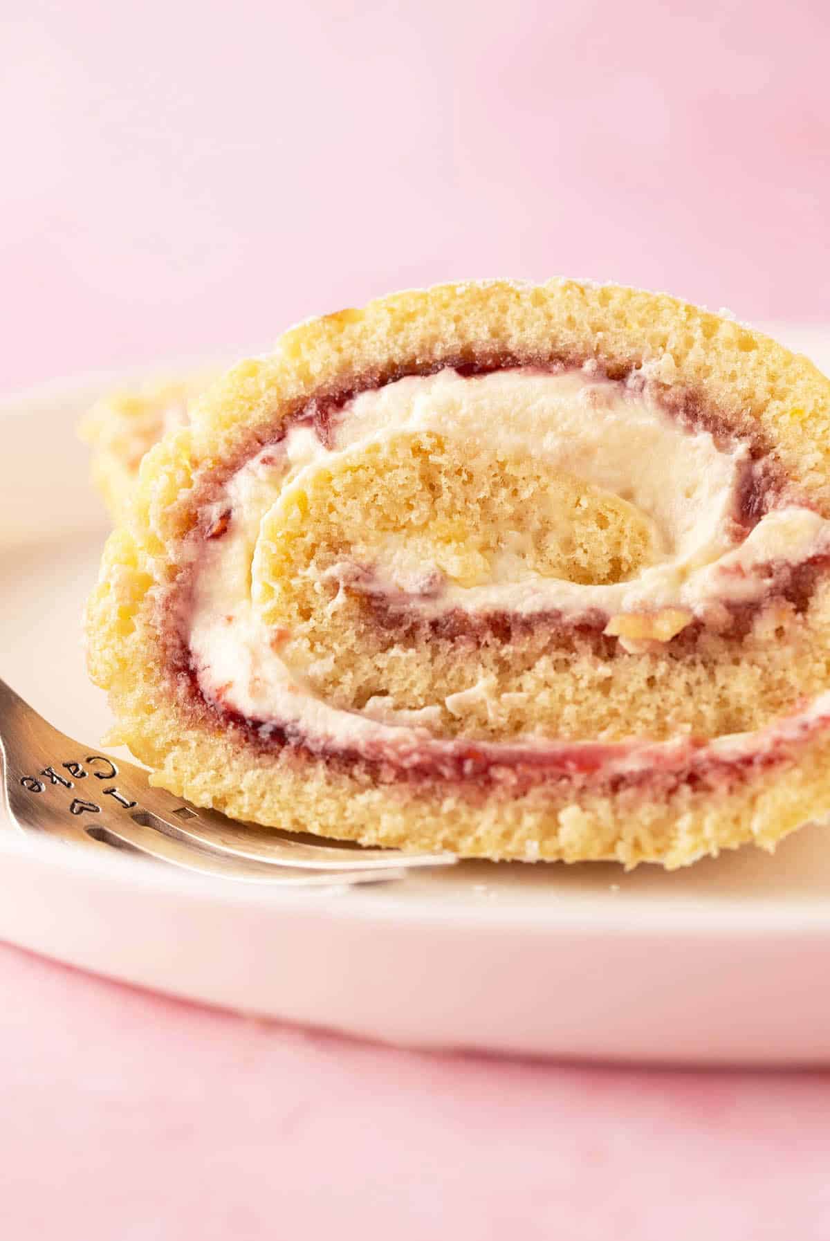 A beautiful Vanilla Swiss Roll Cake filled with jam and cream.