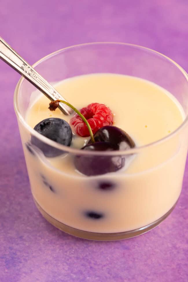 A beautiful jar of homemade custard decorated with fresh berries.