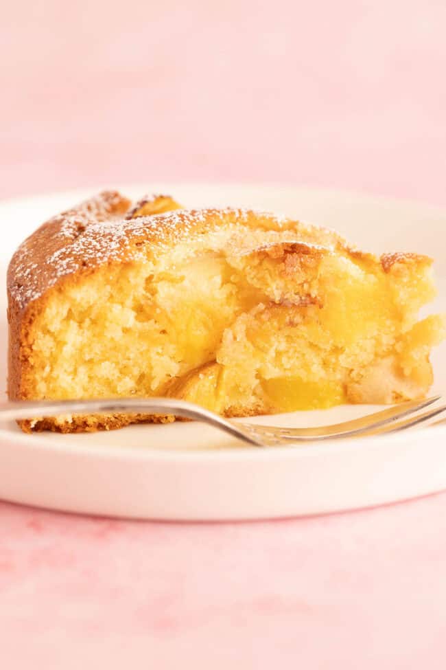 A beautiful slice of Peach Cake on a white plate