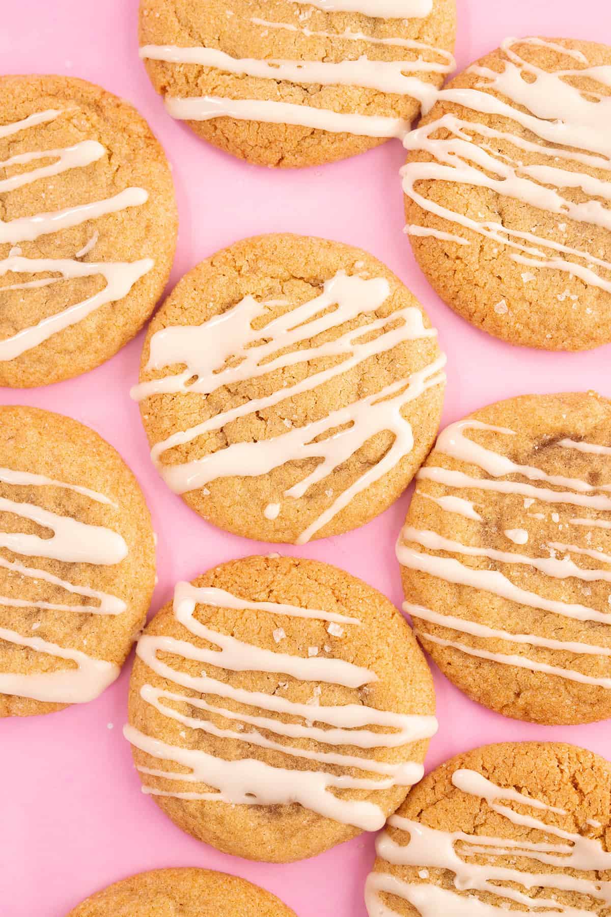 A beautiful top down photo of gingerbread cookies on a pink background.