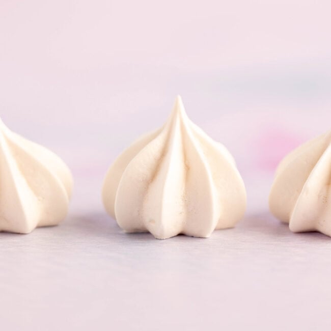 Little meringue kisses on a purple backdrop.