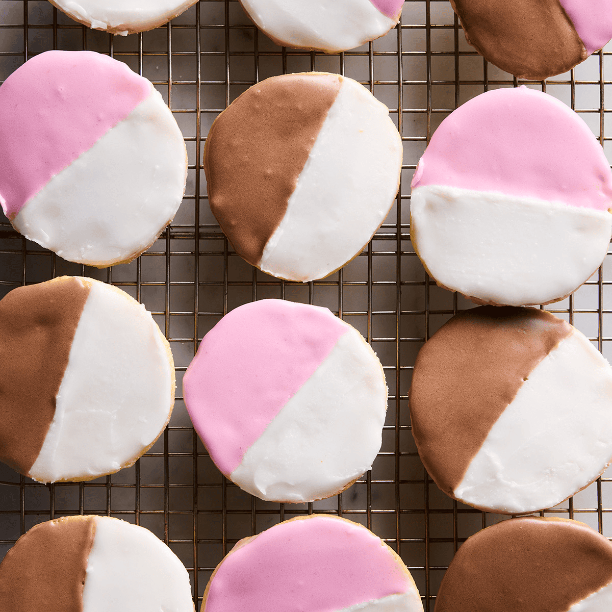 Beautiful black white and pink cookies on a wire rack from Jessica Holmes's cookbook.