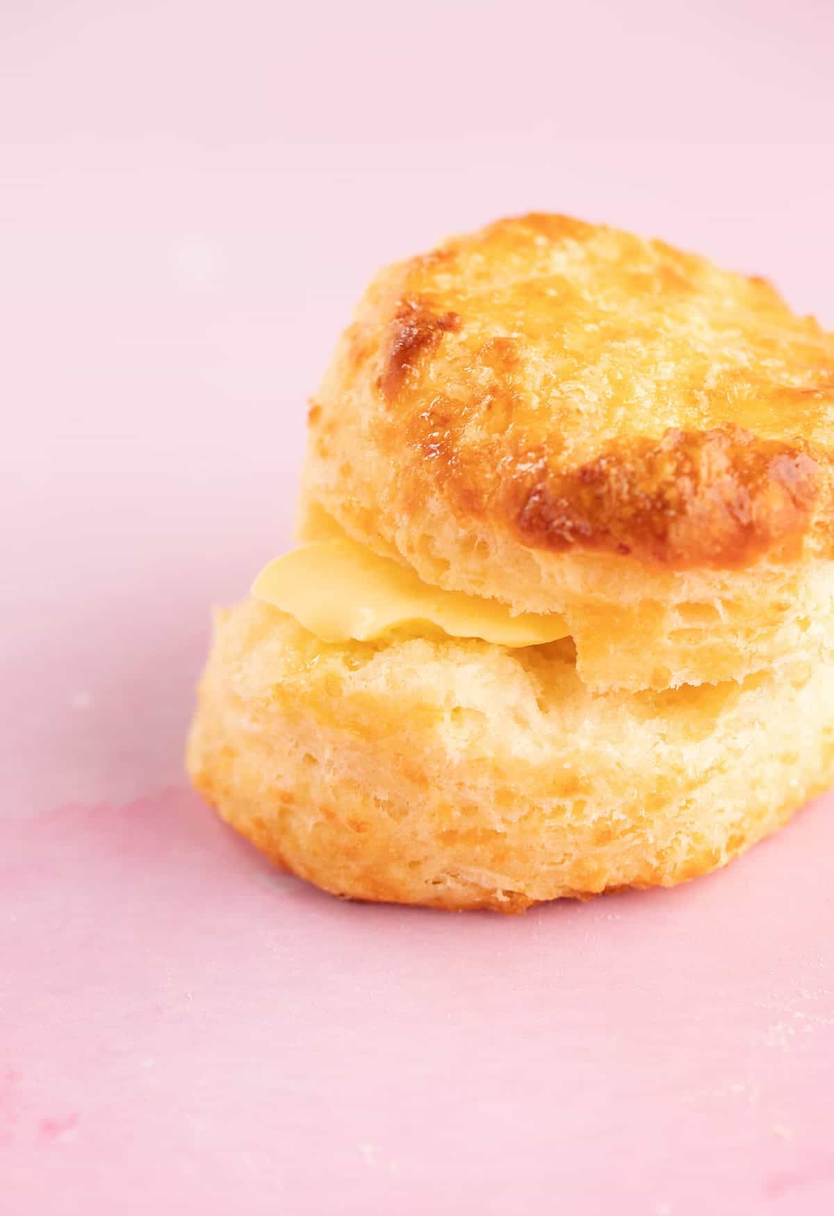 Close up of a cheese scone smothered in butter