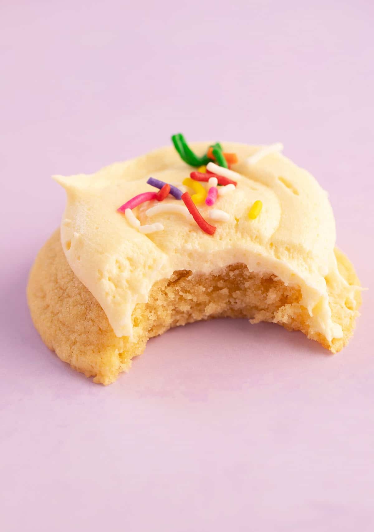 A beautiful cookie with a bite taken out of.